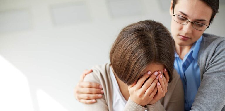 woman is crying and her therapist is comforting her
