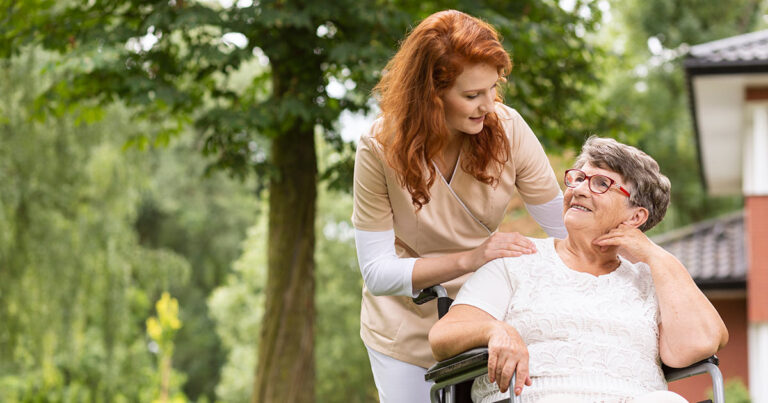 A volunteer nurse helping a woman in a wheel chair